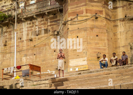 Meditazione del mattino di un vecchio cieco in un accappatoio al ghats nelle rive del Gange varanasi fiume. Foto Stock