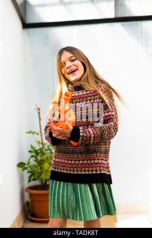 Ritratto di felice ragazza che gioca con il giocattolo di dinosauri a casa Foto Stock