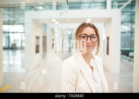 Ritratto di fiducioso giovane imprenditrice con gli occhiali Foto Stock