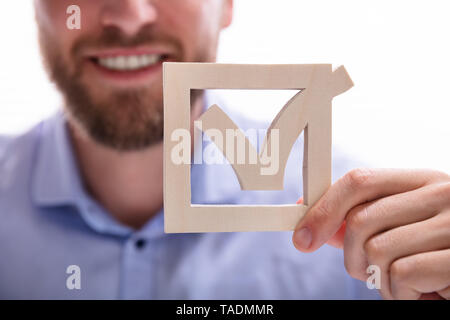 Close-up di un imprenditore di mano azienda Icona segno di spunta verde Foto Stock