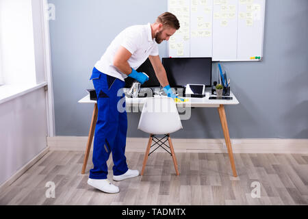 Pulizia del lavoratore Computer Desk con spray e spugna Foto stock - Alamy