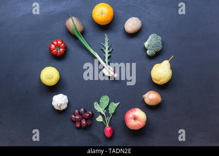 Frutta e verdura orologio edificio sul terreno scuro Foto Stock