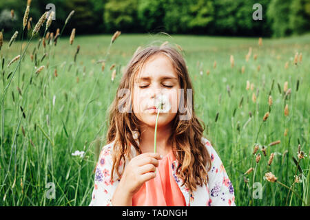 Ritratto di ragazza con blowball su un prato Foto Stock