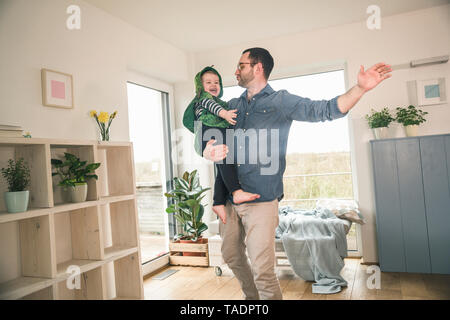 Padre giocando con il figlio felice in un costume a casa Foto Stock