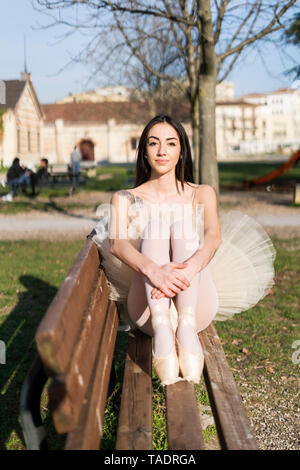 L'Italia, Verona, ritratto di ballerina seduta sul banco in città Foto Stock