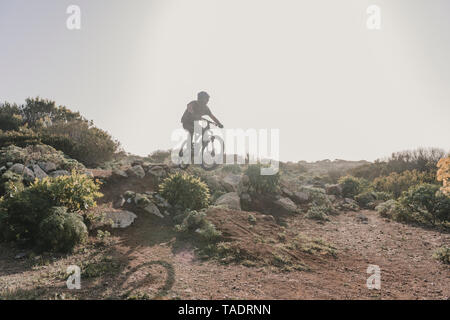 Spagna, Lanzarote, mountainbiker su un viaggio nel paesaggio desertico Foto Stock