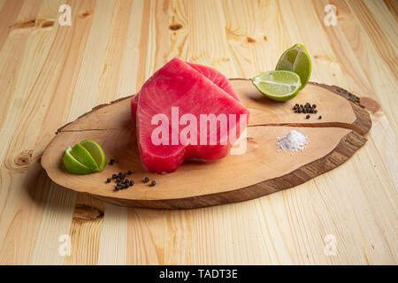 Crudo fresco bistecca di tonno sul tagliere di legno Foto Stock