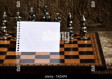 Svuotare Notepad foglio piegato a metà scacchiera Scacchi a tema impostato pezzi Foto Stock