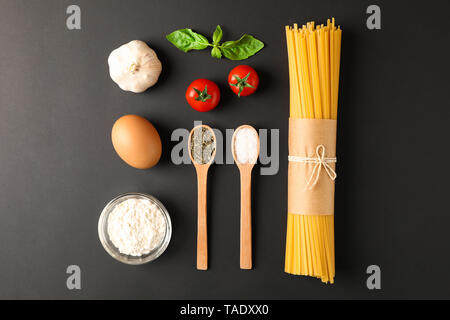 Piano di composizione dei laici con ingredienti per la pasta su sfondo nero, spazio per il testo Foto Stock