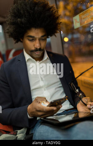 Spagna, Barcellona, imprenditore in un tram notturno tramite telefono cellulare Foto Stock