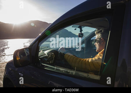 L'Italia, Como, uomo seduto in auto mentre attraversando il lago sul traghetto Foto Stock