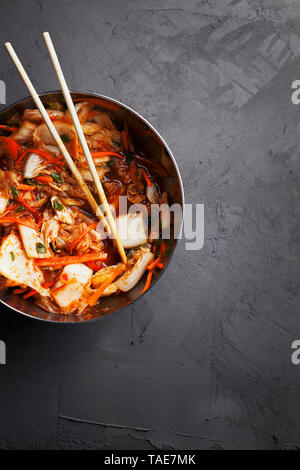 Kimchi Napa piccante cavoli di decapaggio.tradizionale coreano piccante Croccanti verdure fermentate in ciotola su sfondo grigio scuro vista superiore con spazio di copia Foto Stock