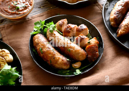 Gustosi piatti fatti in casa salsicce fritte su piastra nera Foto Stock