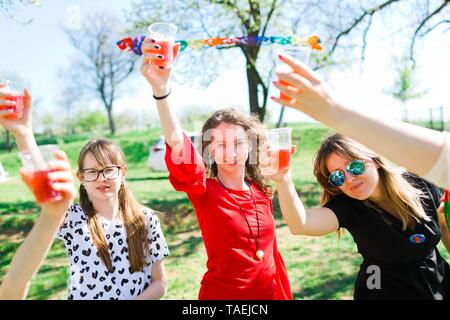 Toast con bambino champagne sul compleanno party in giardino con i bicchieri di plastica Foto Stock
