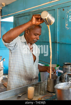 Ritratto verticale di un uomo che fa tè tradizionale o chai in India. Foto Stock