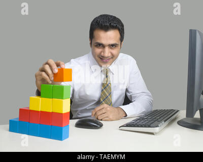 I dirigenti aziendali utilizzando blocchi di costruzione per costruire un edificio concettuale Foto Stock