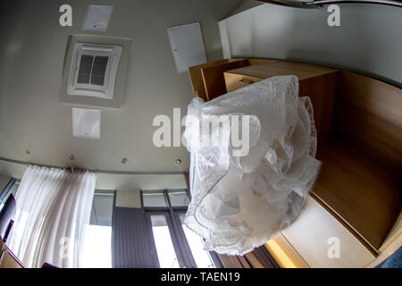 White abito da sposa appeso di armadio in legno. Bianco abito nuziale sulla cremagliera al guardaroba. Abito nuziale per la sposa. Foto Stock