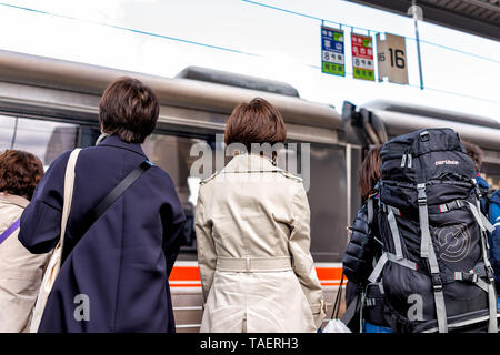 Takayama, Giappone - Aprile 8, 2019: stazione JR e piattaforma con il treno in movimento nella Prefettura di Gifu in Giappone con le persone in attesa di Hida shinkansen in auto numb Foto Stock