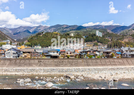 Gero Onsen, Giappone - Aprile 8, 2019: Villaggio cityscape nella Prefettura di Gifu con fiume e vista sulla montagna in primavera primavera durante il giorno Foto Stock