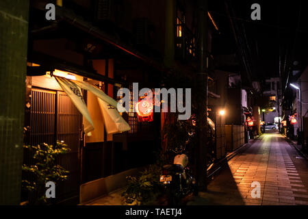 Kyoto, Giappone - Aprile 9, 2019: stretto vicolo colorato empty Street nel quartiere di Gion di notte con la lanterna rossa e il vento che soffia tende Foto Stock