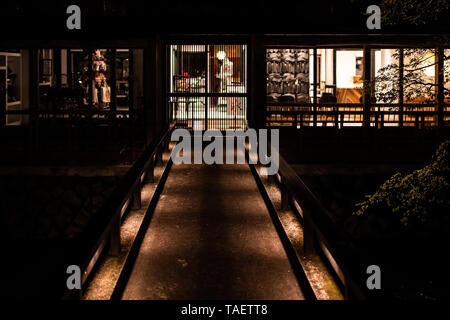 Kyoto, Giappone - Aprile 9, 2019: ponte illuminato al ristorante store shop dal fiume canal in Gion a notte con nessuno Foto Stock