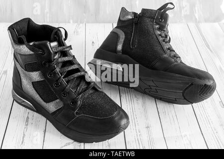 Confortevole sneakers nero con pannelli grigio su una piattaforma elevata con una cerniera lampo e lace-up. Immagine in bianco e nero Foto Stock