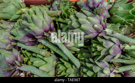 Closeup shot di carciofi in vendita al mercato agricolo. Bella di verdure fresche. Foto Stock