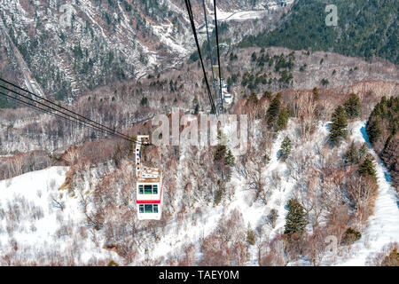 Takayama, Giappone montagna con neve e auto rossa in funivia Shinhotaka vista nella Prefettura di Gifu park sulla giornata di primavera Foto Stock