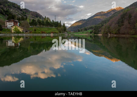 Lago alpino, impostare tra prati e boschi di faggio Foto Stock