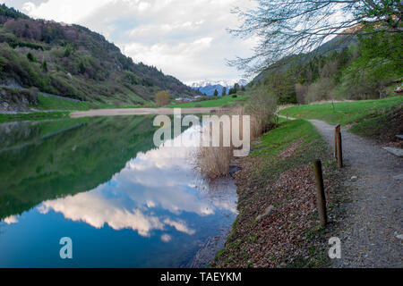 Lago alpino, impostare tra prati e boschi di faggio Foto Stock