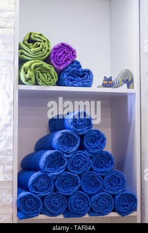 Un pacco di rotoli di asciugamani composto da una piramide su un ripiano in un studio di yoga, spa salone, bagno a casa. Foto Stock