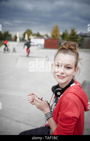 Ritratto di sorridente ragazza adolescente a uno skatepark Foto Stock