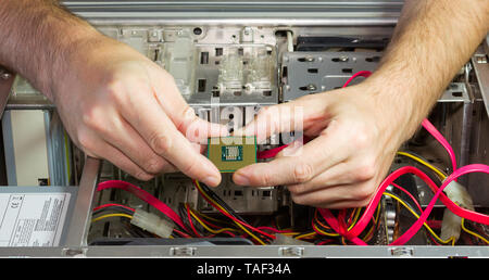 La CPU nelle mani di uomini sullo sfondo della open unità di sistema Foto Stock