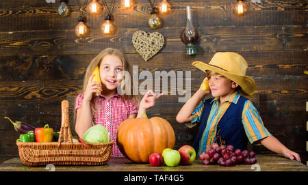 Bambini presentando farm raccolto lo sfondo di legno. Motivi per cui ogni bambino dovrebbe sperimentare l'agricoltura. Responsabile per il daily farm faccende. Gli agricoltori per bambini ragazza ragazzo verdure raccolto. Azienda agricola a conduzione familiare. Foto Stock