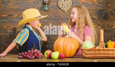 Motivi per cui ogni bambino dovrebbe sperimentare l'agricoltura. Responsabile per il daily farm faccende. Gli agricoltori per bambini ragazza ragazzo verdure raccolto. Azienda agricola a conduzione familiare. Bambini presentando farm raccolto lo sfondo di legno. Foto Stock