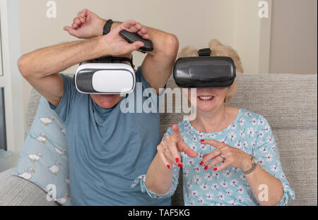 Portsmouth Regno Unito, coppia di anziani divertirsi indossando la realtà virtuale gli occhiali di protezione Foto Stock