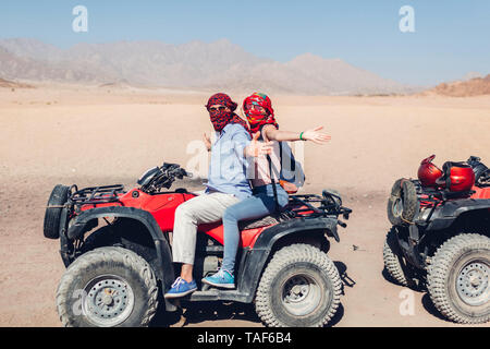 L'uomo e sua figlia la guida moto quad nel deserto del Sinai. La famiglia felice avendo divertimento durante le vacanze estive in Egitto Foto Stock