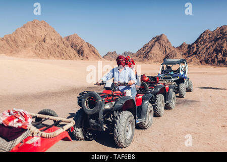 L'uomo e sua figlia la guida moto quad nel deserto del Sinai. La famiglia felice avendo divertimento durante le vacanze estive in Egitto Foto Stock