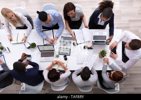 Vista aerea di un businessman a tavola con i laptop avendo discussioni in riunione Foto Stock