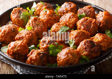 Asian polpette di pollo in una cremosa salsa di cocco con il curry rosso closeup su una piastra sul tavolo orizzontale. Foto Stock