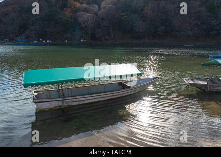 Barca a Hozu-gawa River e Togetsu-kyo Ponte con colorati foresta montana background in Arashiyama, Kyoto, Giappone. Arashiyama è a livello nazionale desig Foto Stock