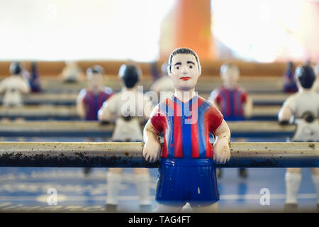 Un tavolo da calcio balilla, calcio balilla, o babyfoot foosball player dipinte a Barcellona FC colori del club. Si tratta di un travagliato vecchio tavolo con mandrini arrugginito Foto Stock