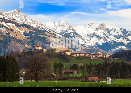La città medievale di Gruyeres e il castello con le montagne sullo sfondo, cantone di Fribourg, Svizzera Foto Stock