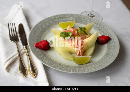 Il prosciutto di Parma e melone starter sulla tovaglia Foto Stock