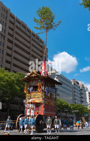 Gion Matsuri Festival, il più famoso festival in Giappone. I partecipanti in abiti tradizionali tirando un altamente decorato enorme galleggiante in parata. Foto Stock