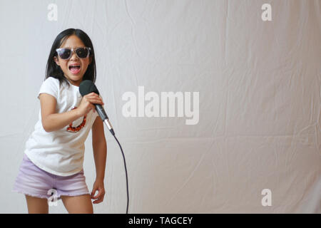 Poco ragazza asiatica suona rock star Foto Stock