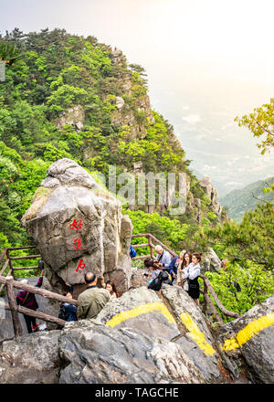 Lushan Jiangxi Cina, 26 Aprile 2018 : vista verticale di turisti cinesi in posa accanto a una grande roccia in Lushan Mountain National Park in Mount Lu Cina Foto Stock