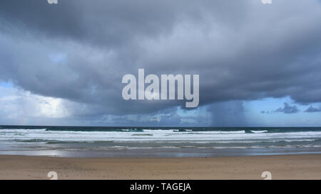 Cielo drammatico con grandi nuvole sulla spiaggia Arrawarra (costa Nord, NSW, Australia). Mare che sgorga in un giorno nuvoloso. Vista orizzontale della drammatica nuvoloso Foto Stock