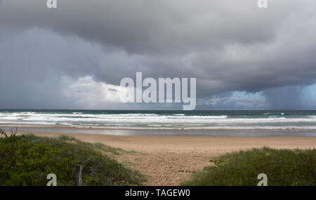 Cielo drammatico con grandi nuvole sulla spiaggia Arrawarra (costa Nord, NSW, Australia). Mare che sgorga in un giorno nuvoloso. Vista orizzontale della drammatica nuvoloso Foto Stock