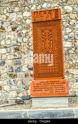 Khor Virap, Armenia, 27 Aprile, 2019:copia del khachkar distrutta nel Jugha con immagini di santi è fissata contro una parete di pietra sulla strada che conduce a t Foto Stock